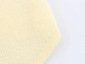 Macro shot of pale yellow knit fabric texture with ribbed edge detail and fine yarn
