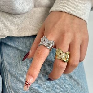 Luxurious gold and silver belt buckle rings with full diamond pavé worn by a model