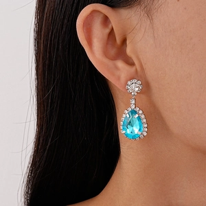 Macro detail of French vintage waterdrop earrings featuring sea blue stones and white zircon