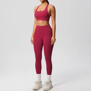 Detalle de conjunto de yoga rojo oscuro de cintura alta con top deportivo y mallas a juego