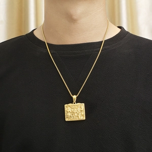 Close-up of gold square pendant with Egyptian pharaoh relief on a box chain for men