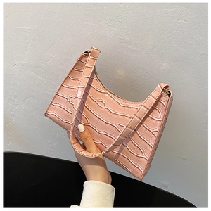 Close-up of pink crocodile embossed texture and zipper on stylish underarm bag