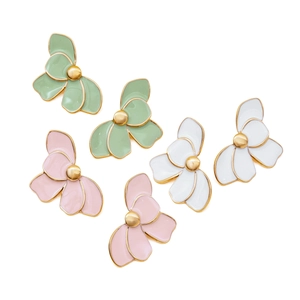 Detail of floral enamel earrings with gold trim in green, pink, and white finishes
