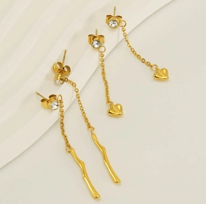 Detail view of gold stainless steel tassel earrings with heart and wave shape pendants