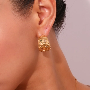 Detail of 18K gold hammer-textured earrings with gemstones and pearls on model