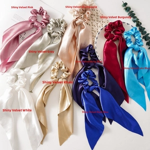 Flat lay of colorful satin hair scrunchies with long ribbons in nine elegant shades