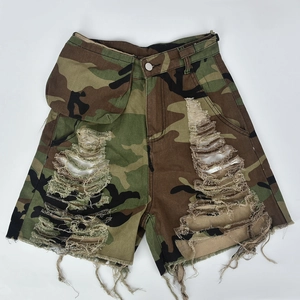 Détail d'un short en jean camouflage avec déchirures usées et bords d'ourlet effilochés