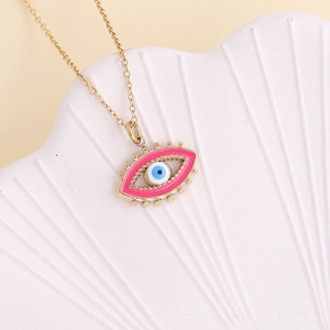 Detail of pink enamel evil eye pendant on a gold stainless steel necklace chain