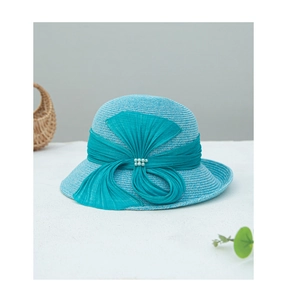 Détail d'un chapeau de soleil en paille bleu clair avec nœud et perles élégantes