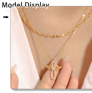 Gros plan sur un collier double rang doré avec pendentif aile d'ange et cœur en zircon