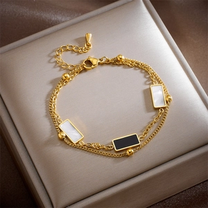 Double-layered gold chain bracelet with geometric black and white rectangular charms