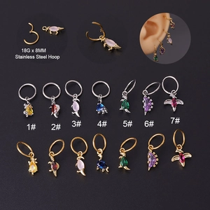 Close-up of 18G stainless steel dinosaur earrings in assorted colors and finishes