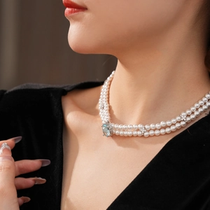 Gros plan d'un collier de perles à deux rangs avec pendentif aigue-marine sur un mannequin