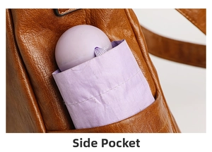 Close-up of side pocket on brown pebble leather tote bag holding a purple folding umbrella