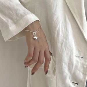 Detail of S925 sterling silver heart bracelet with asymmetric chain and OT clasp on wrist