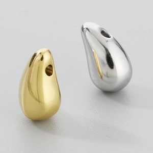 Detailed view of polished teardrop pendants in gold and silver stainless steel finish