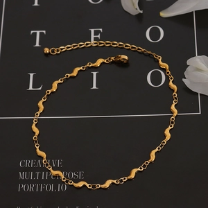 Bracelet de cheville élégant en acier doré 18k avec chaîne ondulée sur fond sombre