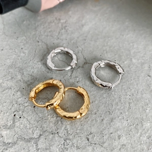Macro view of hammered texture on gold and silver S925 sterling silver hoop earrings