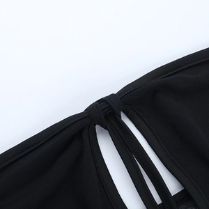 Close-up of black mesh fabric showing hollow-out design and reinforced stitching details