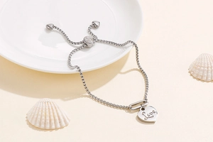 Detailed view of silver heart pendant with Love engraving and adjustable pull chain