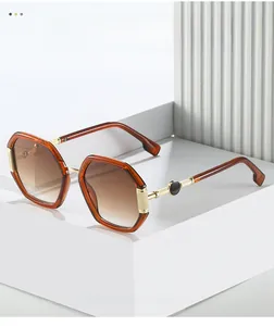 Detail of amber polygon sunglasses with gradient lenses and textured gold metal temples