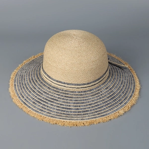 Detail of wide brim sun hat featuring denim blue stripes and rustic frayed edges