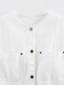 Close-up of neckline and chest pocket on off-white sleeveless denim top in cotton twill