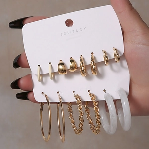 Detail eines 10-teiligen Gold- und weißen Ohrringsets mit Spiral- und C-förmigen Designs