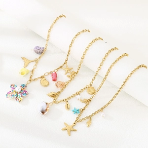 Detailed macro view of gold-plated ocean charms featuring starfish, shell, and floral motifs