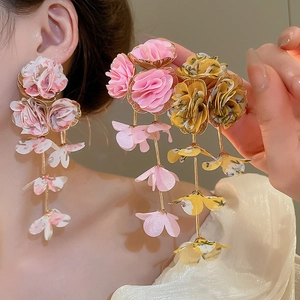 Close-up of pink and yellow fabric flower tassel earrings with intricate petal texture