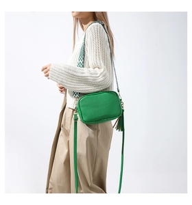 Borsa a tracolla verde motivo litchi con tracolla intrecciata e nappa in pelle