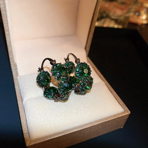 Vintage green crystal hoop earrings with dark metal base in a beige jewelry gift box