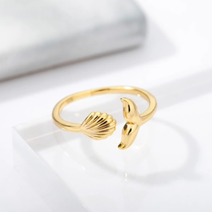 Detail of 18k gold plated whale tail and shell open ring on a clear display stand