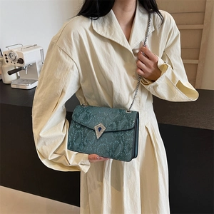 Dark green snakeskin pattern crossbody bag with silver chain strap and diamond buckle