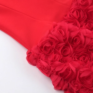 Makro-Detail des roten Minikleids mit texturierten 3D-Chiffon-Rosen und Handwerkskunst