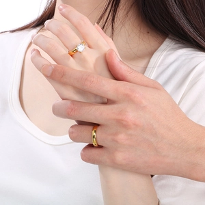 Close-up of gold plated stainless steel wedding ring set with cubic zirconia on hand