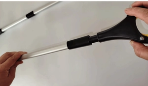 Close-up of aluminum grabber tool showing a secure grip on the handle and foldable joint