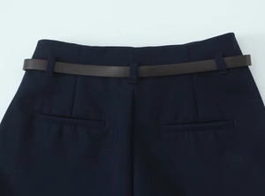 Détails du pantalon bleu marine avec poches arrière et ceinture marron foncé assortie
