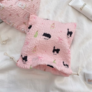 Detailed close-up of pink seersucker drawstring pouch with cute cartoon cat and fruit print