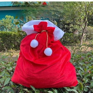 Detail of red velvet Christmas gift sack with white faux fur trim and gold drawstring