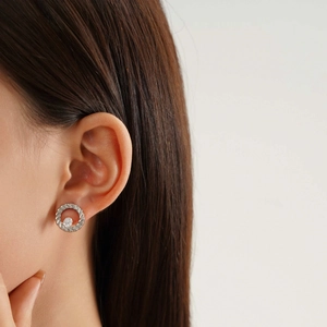 Detailed close-up of a silver twisted rope hoop earring with a sparkling center stone