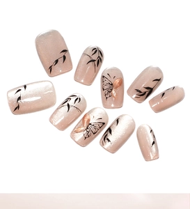 Détails de faux ongles œil-de-chat nude avec feuilles de bambou et papillons 3D décoratifs