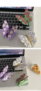 Detail view of butterfly hair claws with flower accents and a pizza-shaped hair clip