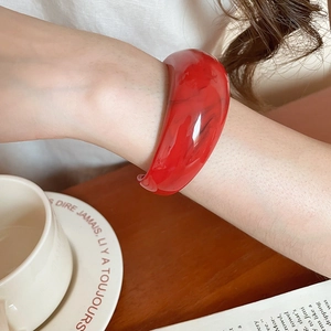 Chic red resin bangle with marble texture shown in an elegant lifestyle setting