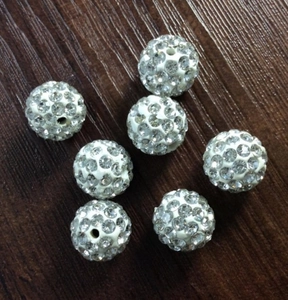 Detail view of white rhinestone clay Shamballa beads for DIY jewelry making supplies