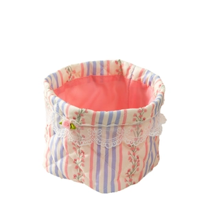 Quilted floral fabric storage basket with pink rose accents and white lace trimming
