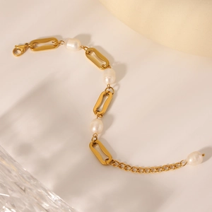 Detail of 18K gold-plated paperclip chain bracelet with white freshwater pearls