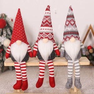 Gros plan de trois gnomes de Noël aux longues jambes sur un banc en bois au décor festif