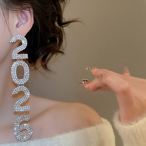 Close-up of sparkling rhinestone 2026 tassels on long silver needle earrings for party wear