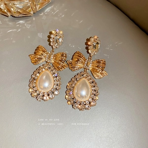 Boucles d'oreilles nœud dorées avec cristaux et perles en forme de goutte d'eau